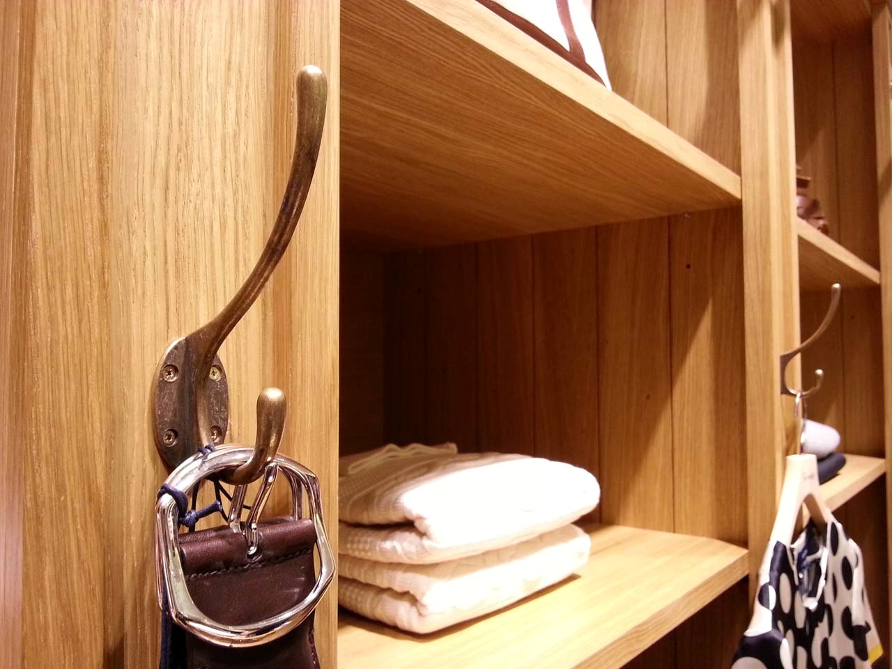 Façonnable boutique — folded knitwear on timber shelving