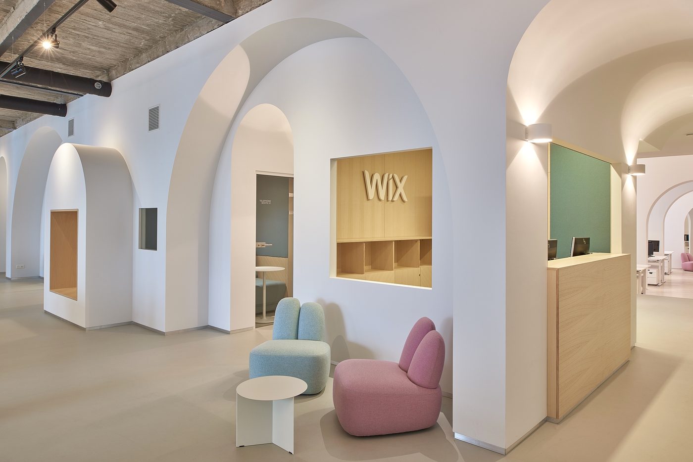 Wix offices — reception with branded wall and armchairs